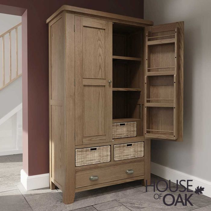 a natural oak larder placed in the corner of a room with wood floor next to a doorway with a hallway in the background