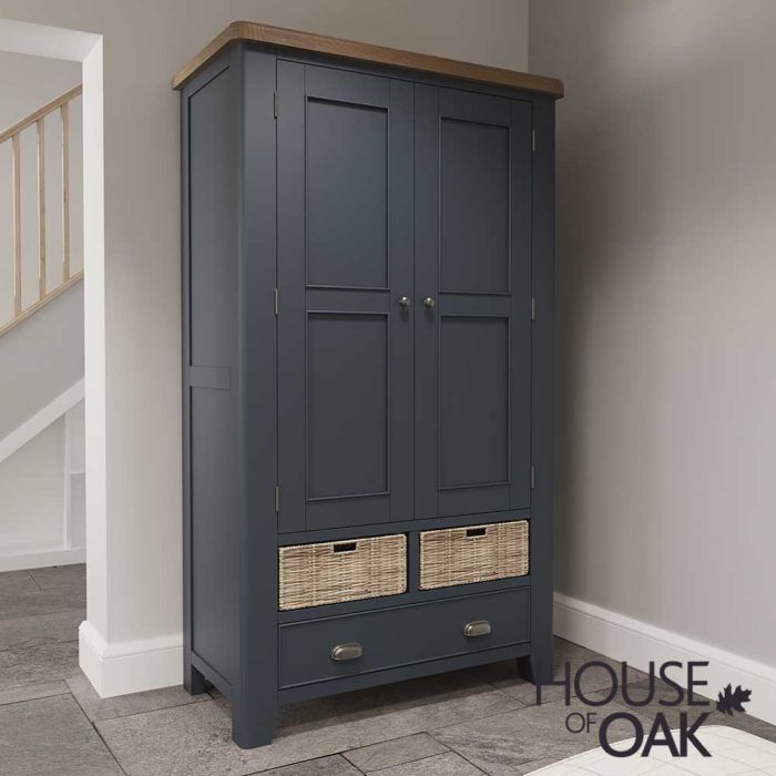 a painted blue oak larder place with wicker drawers in the corner of a room with wood floor next to a doorway with a hallway in the background